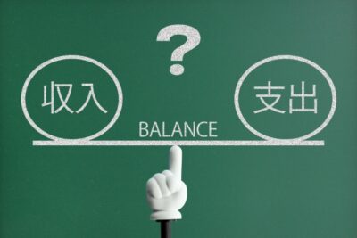高卒投資家の収入と支出のバランスを表す天秤